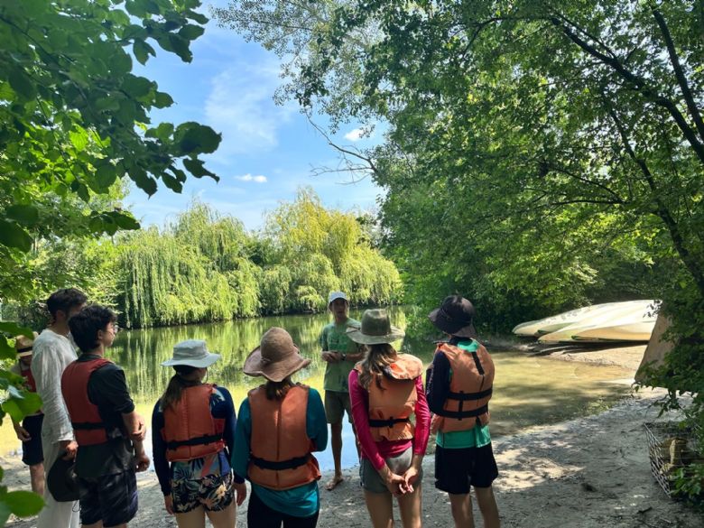 Upper School students by the river before kayaking
